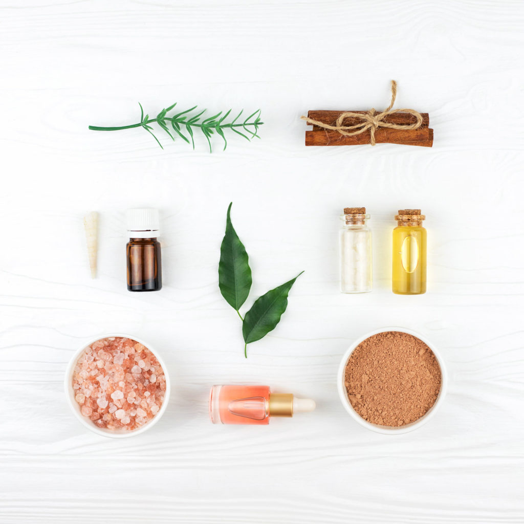 Homemade spa cosmetic set with salt and oils on wooden background.